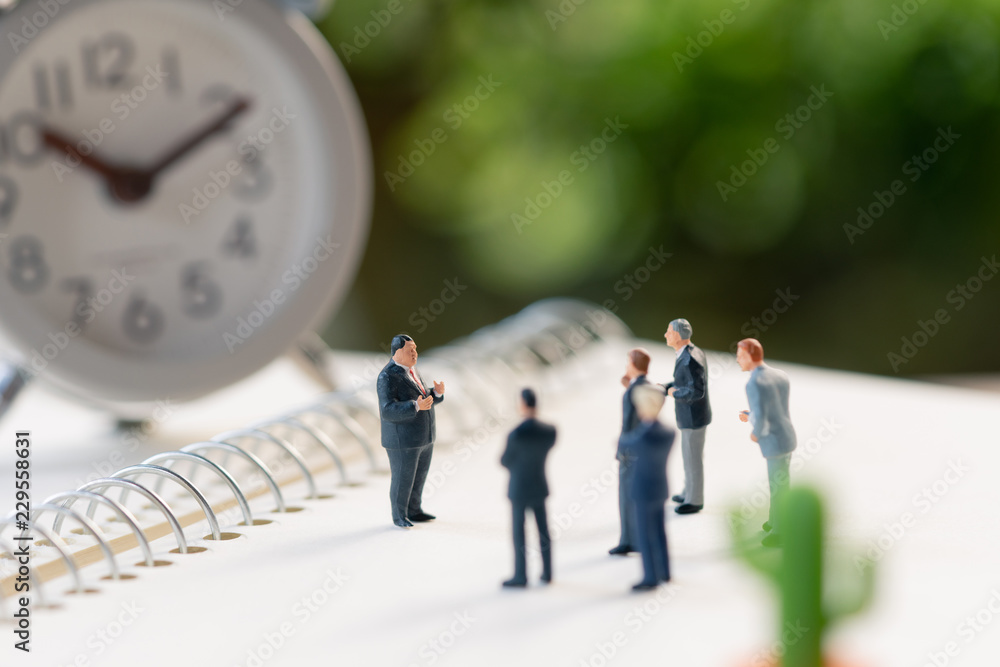 Miniature people meeting on a NoteBook . meeting or Discussion using as background business concept with copy space and white space for your text or design. Miniature people meeting on a NoteBook . meeting or Discussion using as background business concept with copy space and white space for your text or design.