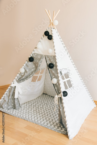 Interior room for a child. Tent for game. Wigwam with a garland of cotton balls. White and grey