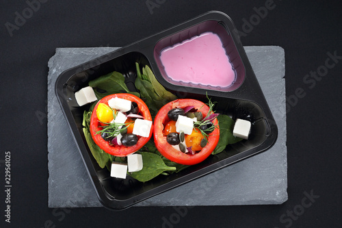 Catering dietetyczny, pomidory faszerowane warzywami z sosem jogurtowym.
Pomidory faszerowane oliwkami, serem feta, szpinakiem podane w pojemniku plastikowym.
