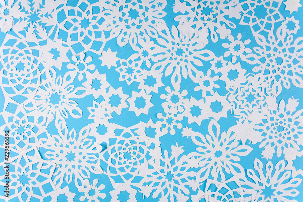 Paper snowflakes on blue background. Top view. Christmas decoration