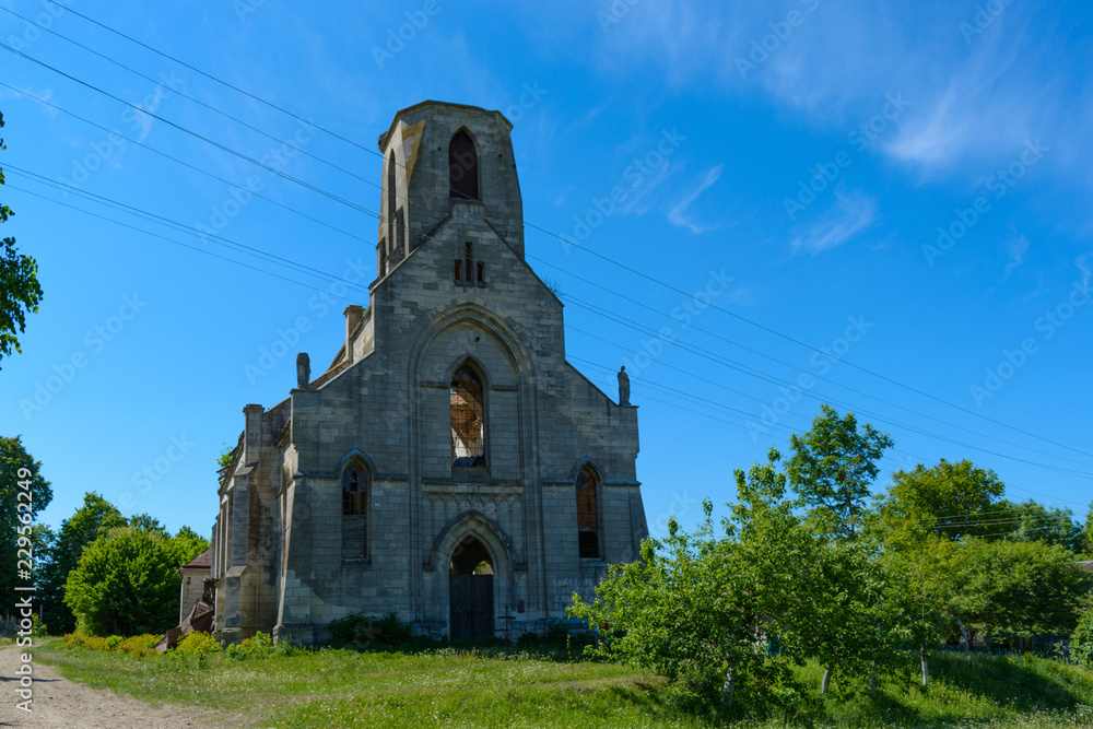 MYL'NE, TERNOPIL REGION, UKRAINE 12 MAY 2018: An old Catholic church that is not used and is abandoned to the backgrounds of a blue sunny sky with clouds.