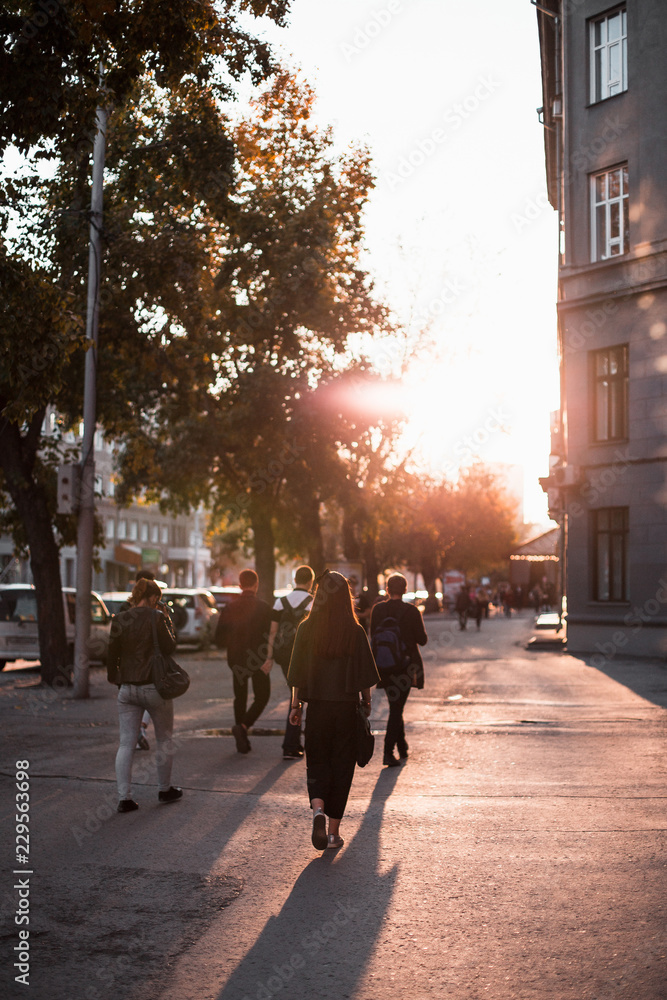 People walk in streets of at sunset