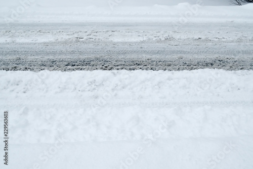 Winter Driving Background - snowy road with tire tracks 