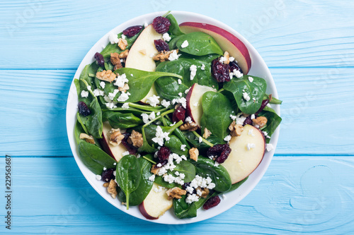 Autumn spinach salad with apple , cheese , walnut and dried cranberry