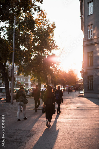 People walk in streets of at sunset