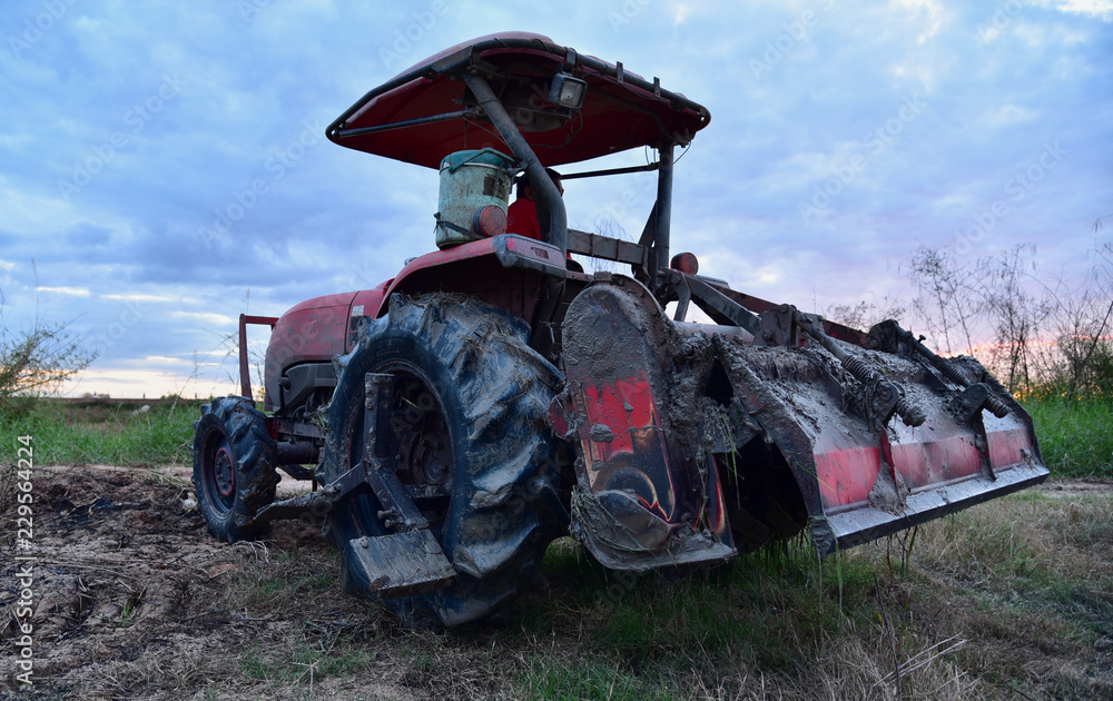 Obraz premium Farmer in tractor preparing farmland. Tractor in rice fields.