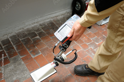Dosimetrist holding a portable gamma radiation dosimeter set on a long fixture (probe)