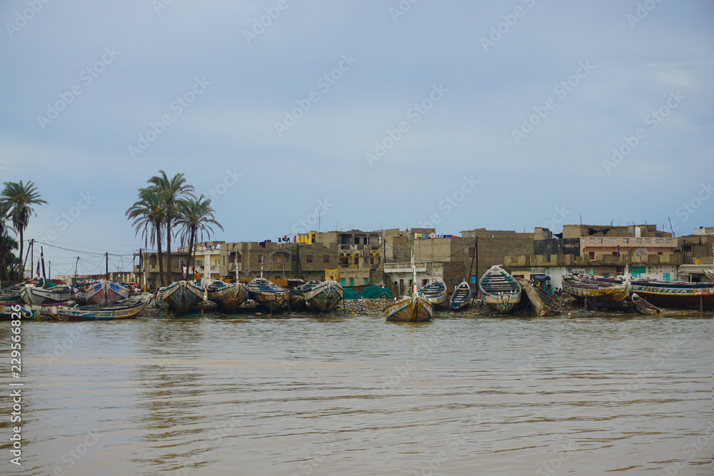 Panoramic view os Saint Louis city in Senegal from the coastline of the river  with fishermen boats and old houses
