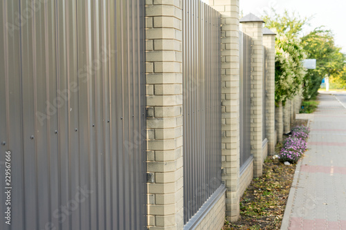 Metal fence private area with columns of brick.