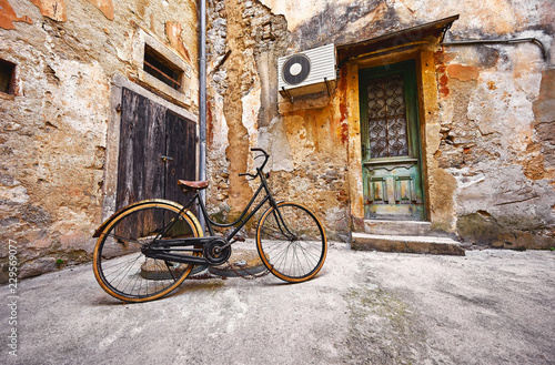 Naklejka na ścianę Stary retro bicykl na rocznik ulicie w Chorwacja tle starzejącym się