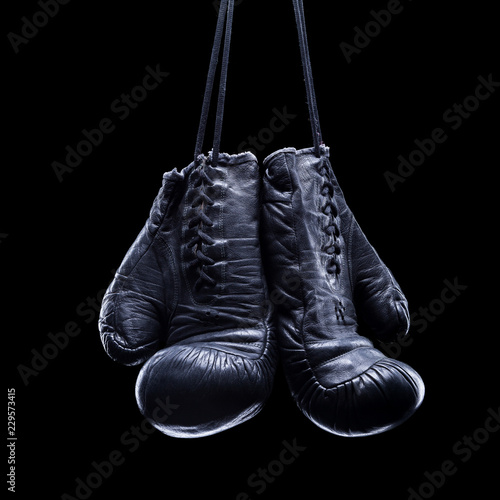 Old boxing gloves on an isolated black background