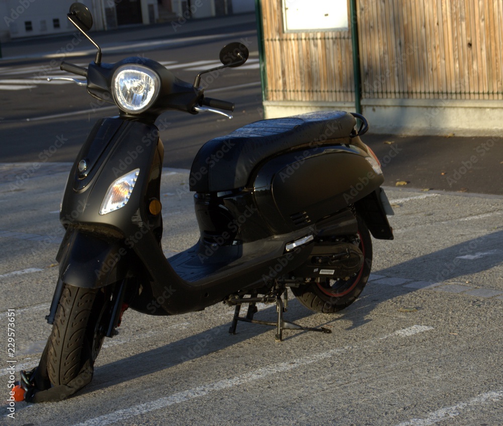 scooter noir sur parking ,stationnement