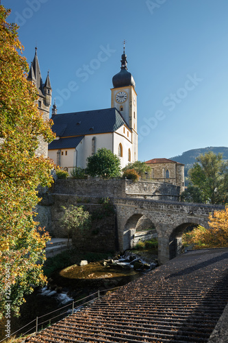 Old catholic church and stone arch bridge on a sunny autumn day. Waidhofen an der Ybbs, Lower Austria.