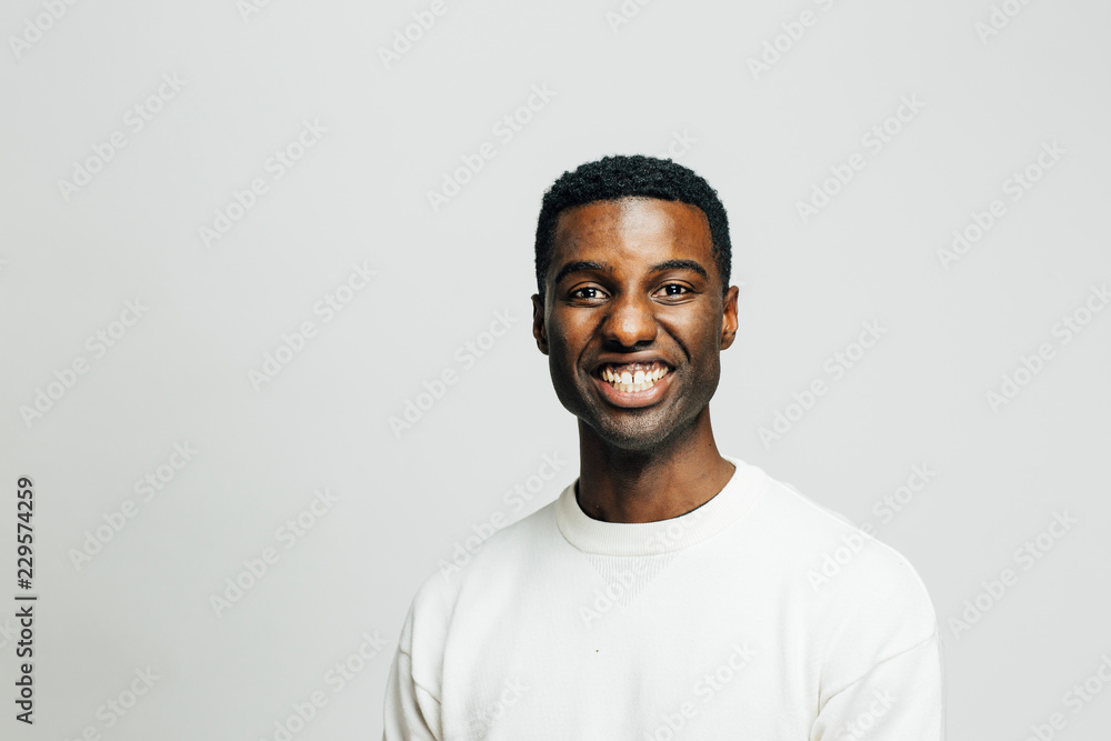 Obraz premium Portrait of a cheerful young man smiling at camera, isolated on white studio background