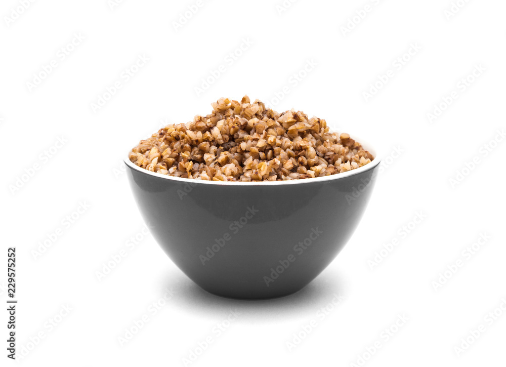 Dry buckwheat in grey color ceramic bowl isolated on white Dry buckwheat in grey color ceramic bowl isolated on white