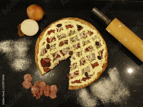 pizza with ingredients on wooden table
