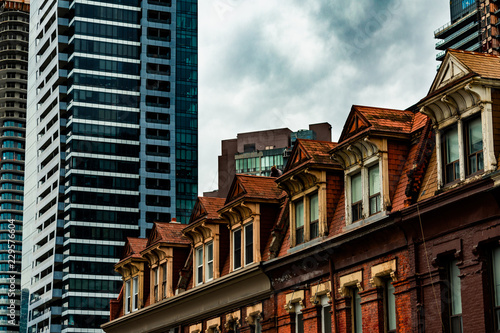 The Tops of Old Brick Buildings Surrounded by Skyscrapers in Downtown Toronto photo