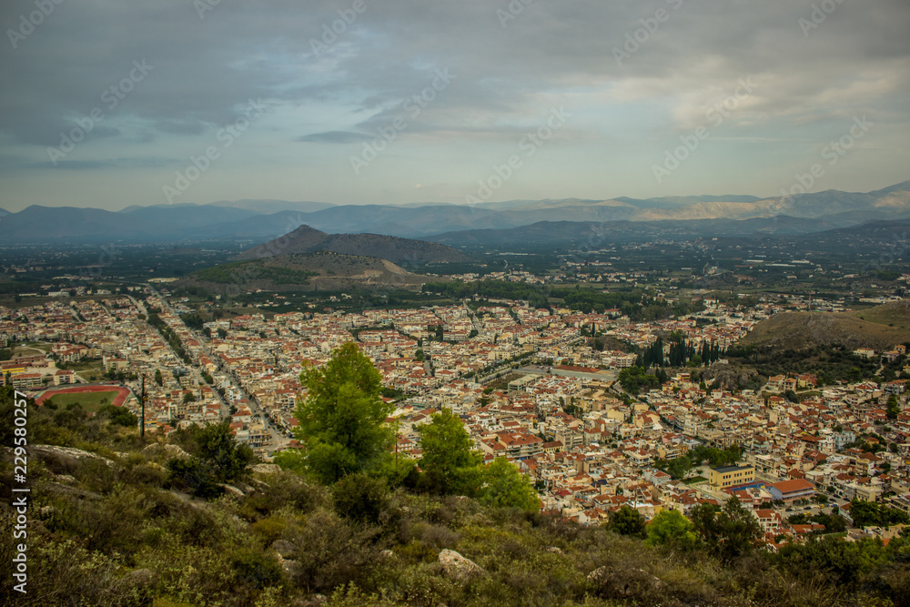 small city from above aerial shot between mountains scenery landscape view in evening time and cloudy and rainy weather