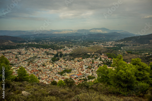 small city from above aerial shot between mountains scenery landscape view in evening time and cloudy and rainy weather