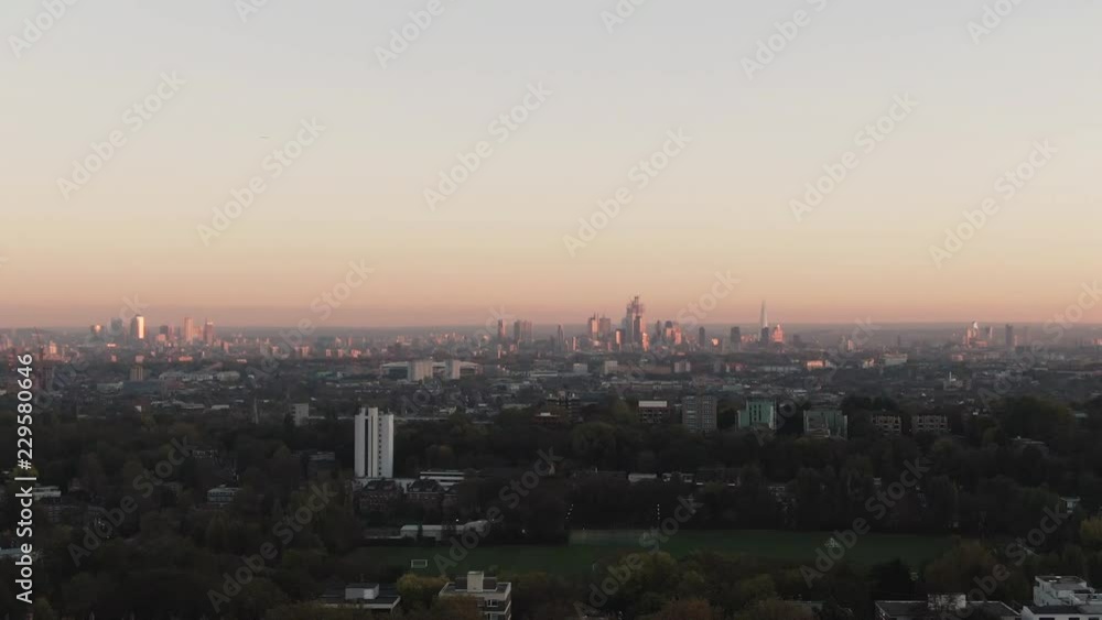 Aerial dolly view of the skyline of London from a park on the North side at sunset Aerial dolly view of the skyline of London from a park on the North side at sunset