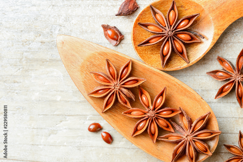 star anise fruits in the wooden spoon, on the board, top view star anise fruits in the wooden spoon, on the board, top view