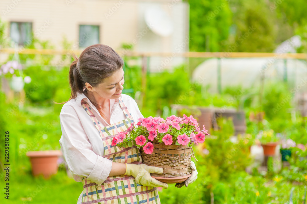 Young woman with flowers at back yard. Empty space for text Young woman with flowers at back yard. Empty space for text