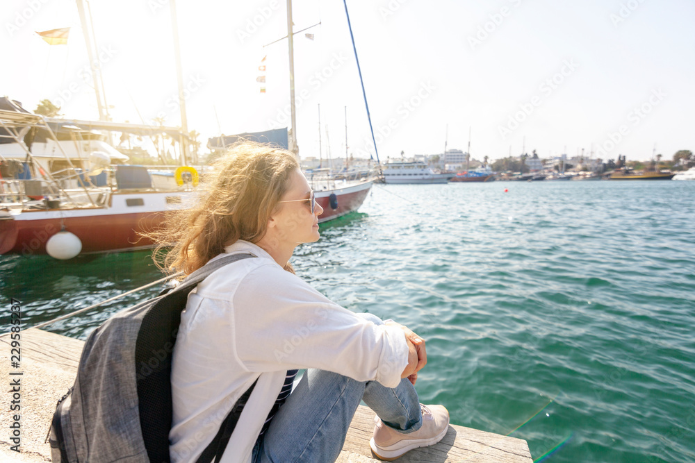 Happy beautiful young woman woman on sea and port background, travel, vacation at sea