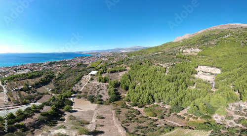 Aerial panoramic view of European village near Split. Green mountains local's farms and vegetation growing. Travel destination in Croatia.