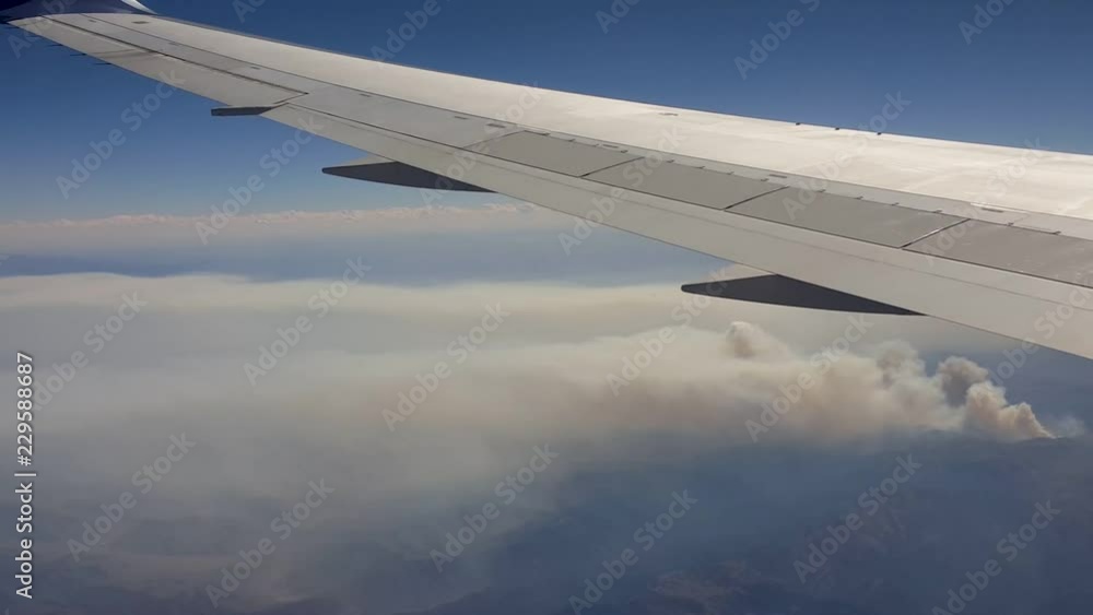 POV-Aircraft wing - flying over wildfires burning in the Bridger-Teton National Forest in western Wyoming as seen from airliner at high altitude POV-Aircraft wing - flying over wildfires burning in the Bridger-Teton National Forest in western Wyoming as seen from airliner at high altitude