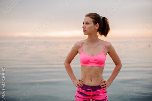Girl standing on the seaside and looking at the distance