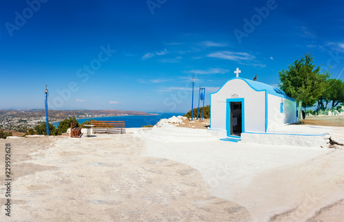 Orthodox church on hill with Faliraki beach in background (Rhodes, Greece)