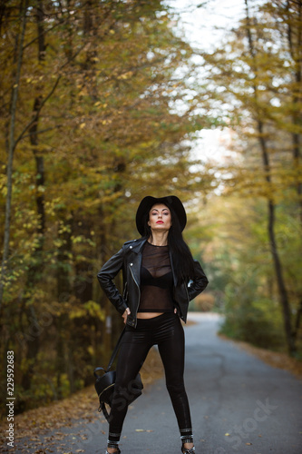 Young woman posing a an autumn day on a road in the woods.