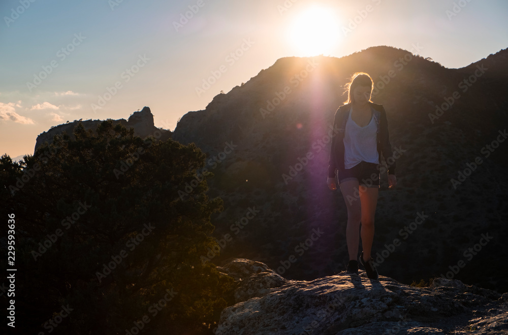 Girl in the mountains on top at sunset or dawn Girl in the mountains on top at sunset or dawn