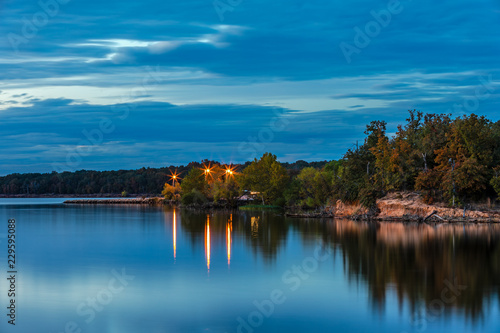 Fototapeta Naklejka Na Ścianę i Meble -  Long exposure of lights reflecting in the water at a lake.