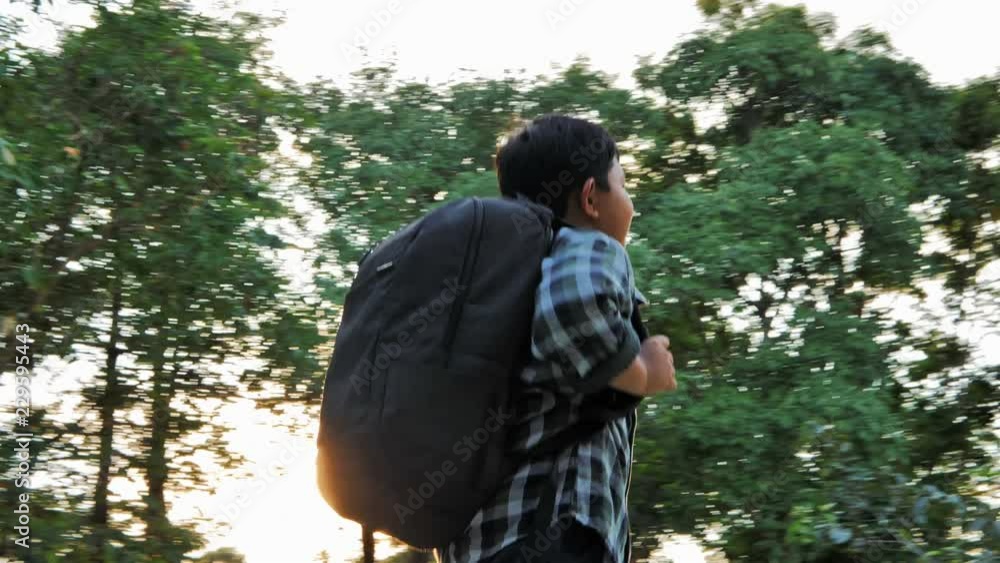 Asian children with backpack are walking and sunlight in the park. Asian children with backpack are walking and sunlight in the park.