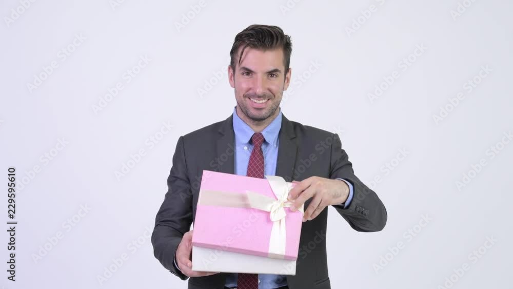 Young happy Hispanic businessman opening gift box Young happy Hispanic businessman opening gift box