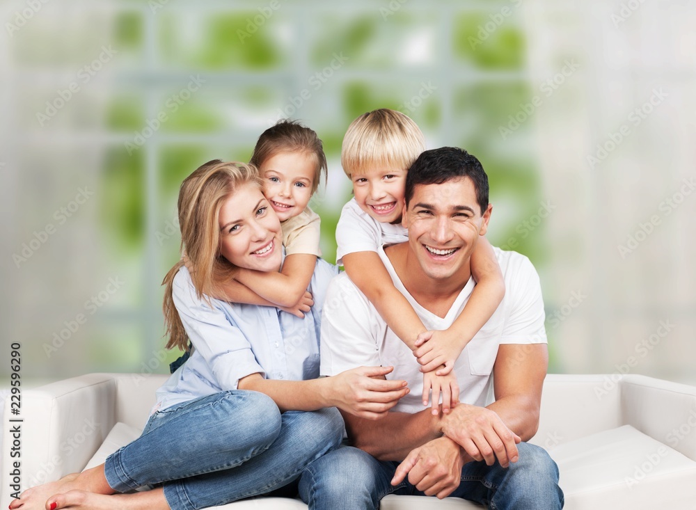 Beautiful smiling family sitting at sofa at home Beautiful smiling family sitting at sofa at home