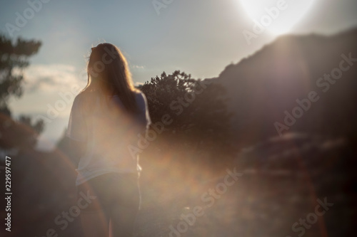 Girl in the mountains on top at sunset or dawn