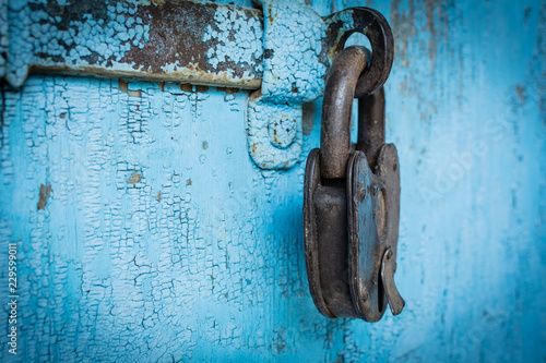 Rusty grunge padlock on old blue wood wall background