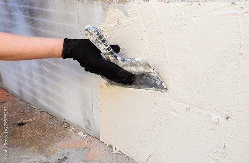 applying white putty on the wall