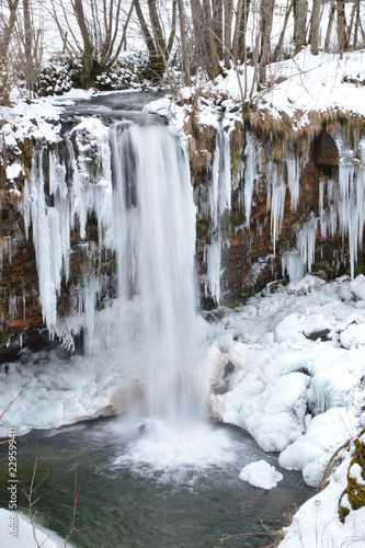 beautiful waterfall during the winter with snow