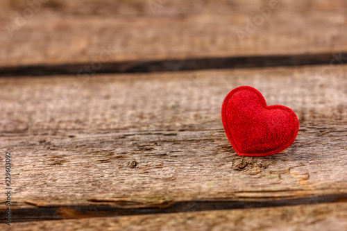 a beautiful red heart lies on a wooden background