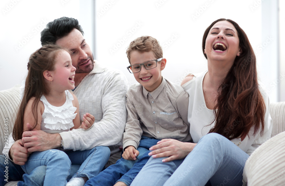 loving parents with children sitting on the couch loving parents with children sitting on the couch