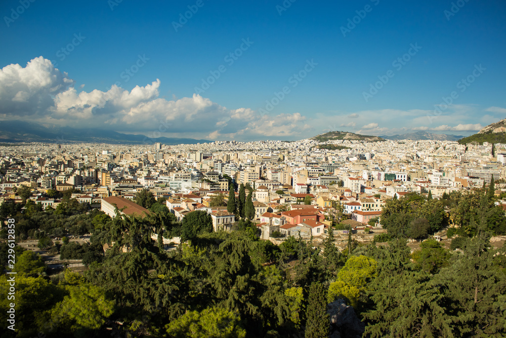 Scenery landscape of Athens - capital of Greece with view on mountain, houses and horizon line with blue sky with clouds from top of hill