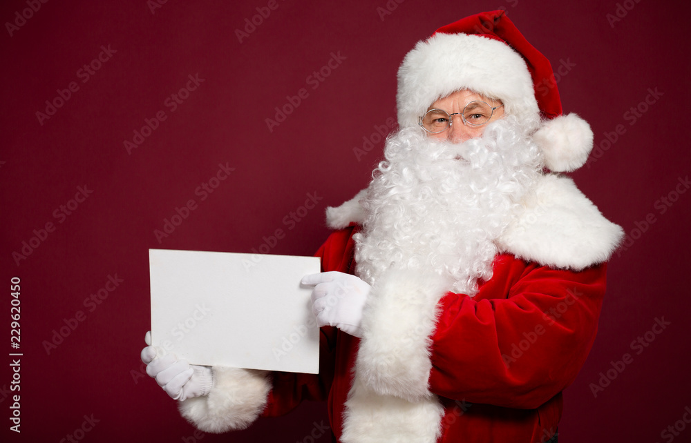 Happy grandfather Santa Clause showing white blank poster or board on red background, Christmas and New year concept