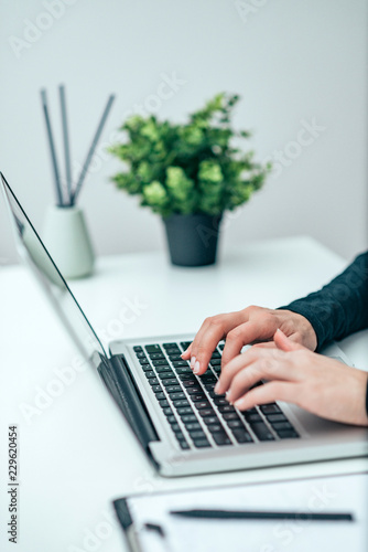 Close-up image of female person using laptop.