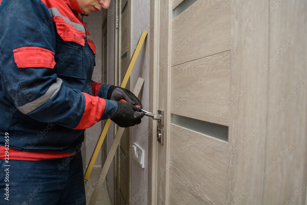 Naklejka premium Male carpenter at interior wood installation and working with level measuring tape