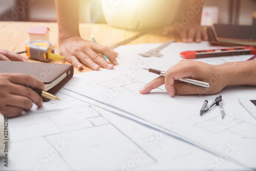 Architects engineer discussing on desk with blueprint. Team group on construciton site check documents and business workflow.Construction concept. Engineering tools.Vintage effect.Selective focus.
