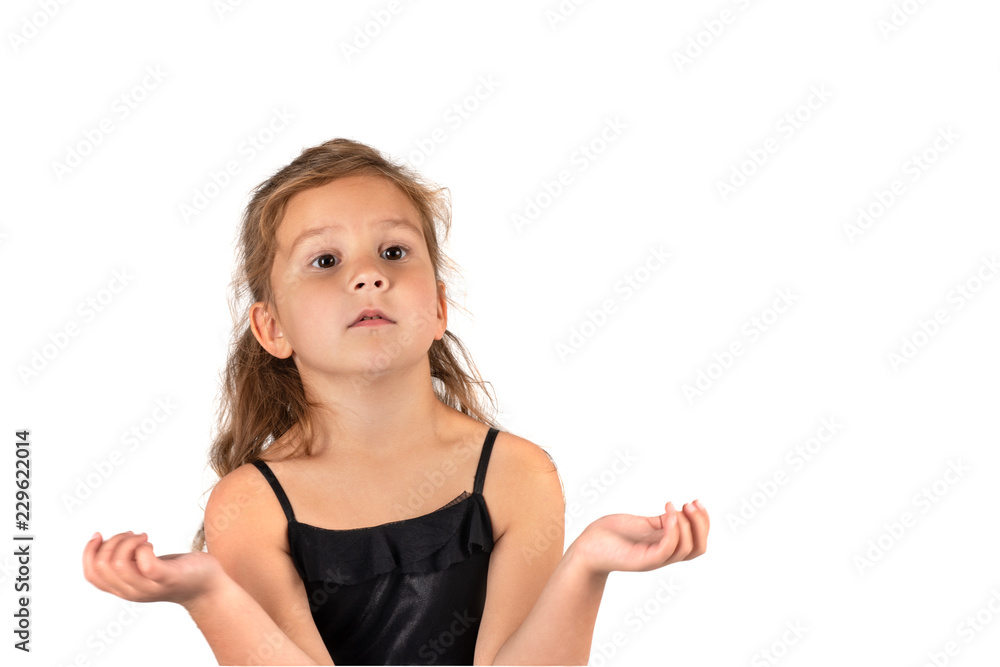 Waist up portrait of a little serious girl wearing beautiful black elegant dress. She is surprised and spreads her arms to the side, on a white background in the studio Waist up portrait of a little serious girl wearing beautiful black elegant dress. She is surprised and spreads her arms to the side, on a white background in the studio