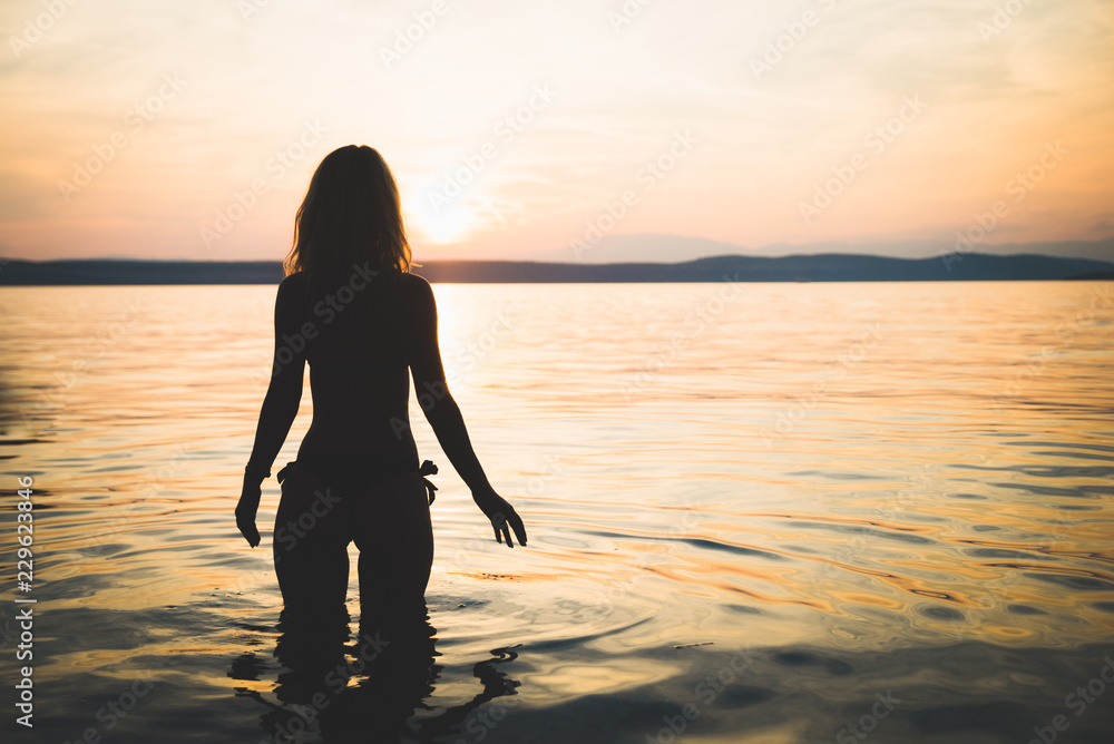 Young attractive girl model silhouette in the sea